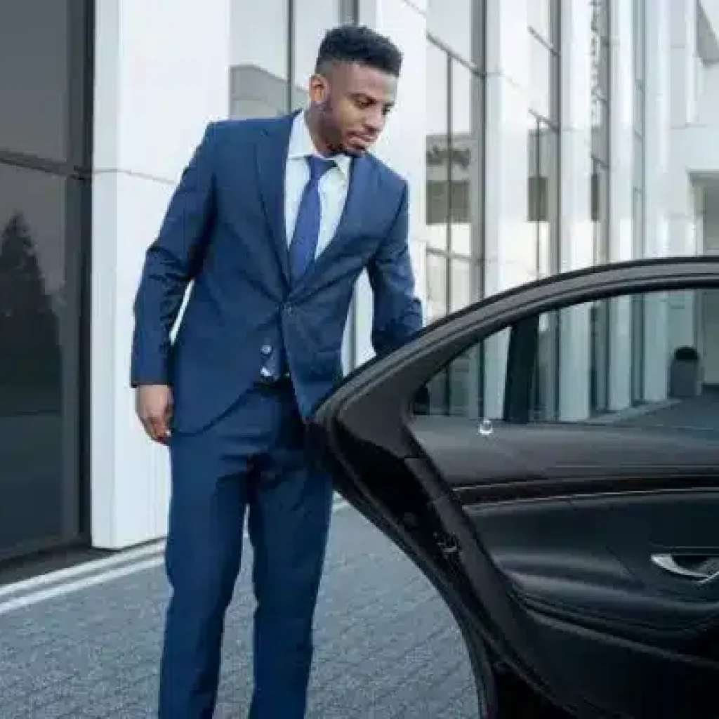 Chauffeur opening luxury car door for airport transfer in NYC