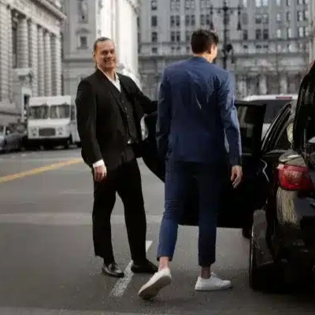 Executive chauffeur assisting business traveler during premium car service in New York City