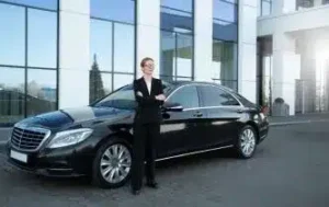 Professional chauffeur standing beside luxury sedan – VIP Connection executive transportation service in NYC